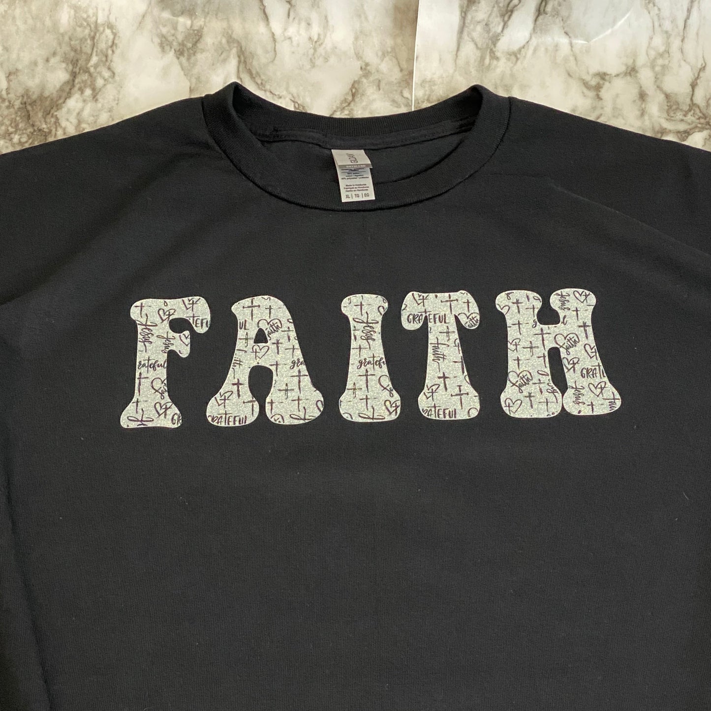 Close Up of Glittery FAITH with Black and White Cross Pattern T-Shirt